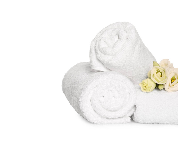 Morbidi asciugamani in spugna con bellissimi fiori su sfondo bianco - Foto, immagini