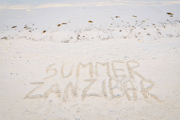 Kuva Sansibarin hiekkarannasta, johon on kaiverrettu sana "Sansibar". Tämä kuva edustaa käsitettä loma ja ylellinen matka - Valokuva, kuva