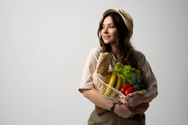 Portrait of young woman with a eco bag of vegetables, greens. Sustainable lifestyle. Eco friendly concept - Фото, зображення