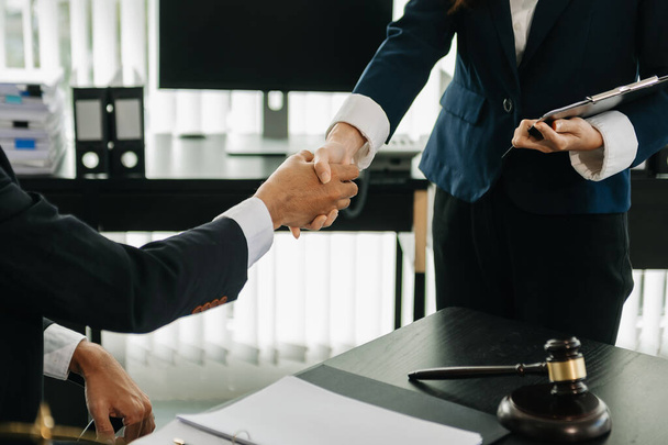  lawyer and  client shaking hands collaborate on working agreements with contract documents at the office - Фото, изображение