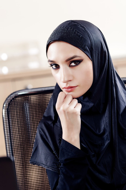 Portrait de la belle femme musulmane assise sur une chaise de bureau
 - Photo, image