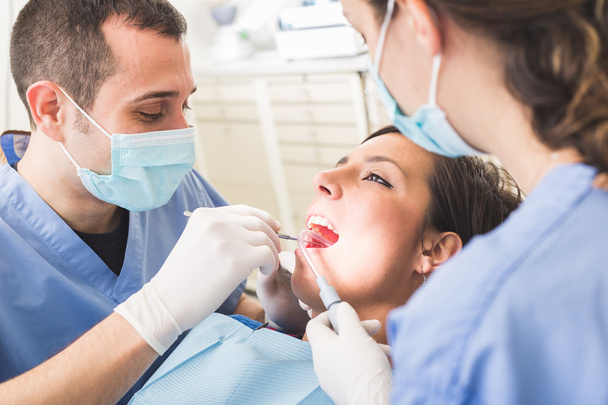 Dentist and Dental Assistant examining Patient teeth. - Foto, Bild