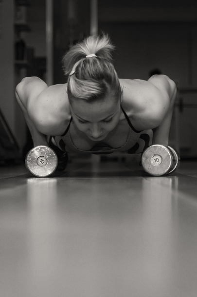 Girl pushing from the floor with dumbbells - Photo, Image