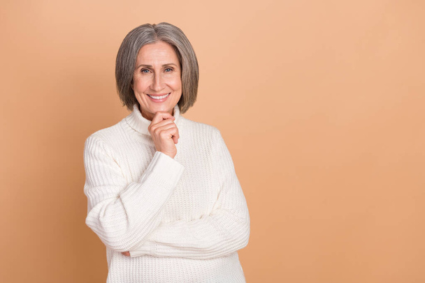 Photo portrait of pretty elderly grandmother thoughtful guess genius plan touch chin wear trendy warm sweater isolated on beige color background. - 写真・画像