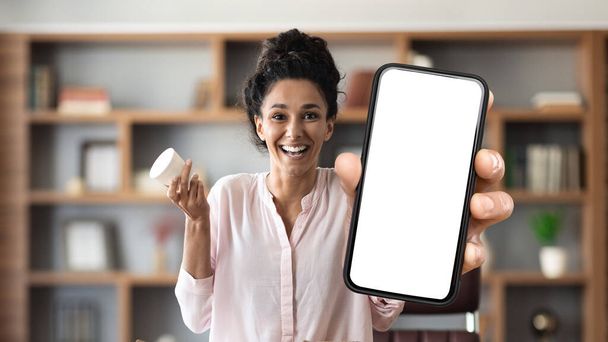 Beauty App. Happy Beautiful Woman Showing Big Blank Smartphone And Holding Cream Jar, Young Female Demonstrating Mobile Phone With White Screen For Application Design, Collage, Mockup - Photo, Image