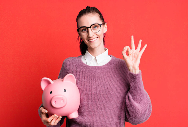 young pretty woman with a piggy bank - Foto, Imagen