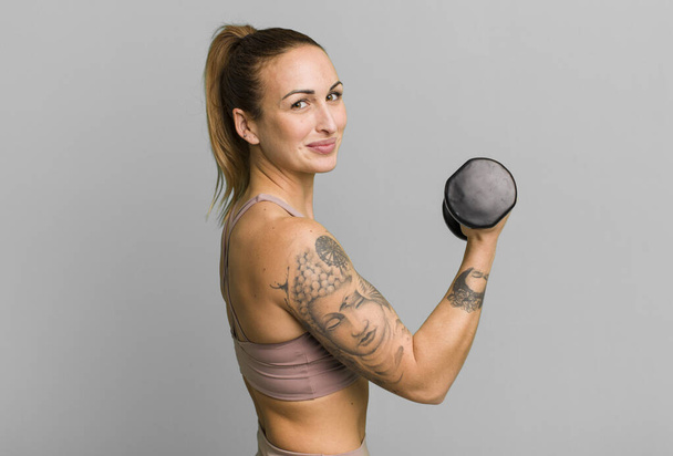 young pretty woman with dumbbell - Fotografie, Obrázek