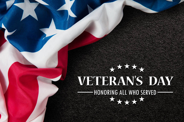 Closeup of American flag with Text Veterans Day Honoring All Who Served on black textured background. American holiday banner. - Photo, image