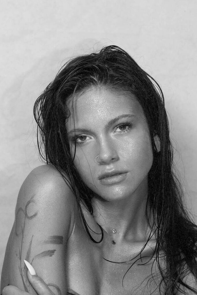 Close-up portrait of beautiful woman's purity face. Model with wet clean shiny skin. Small drops on the skin. Black and white photo. - Фото, зображення