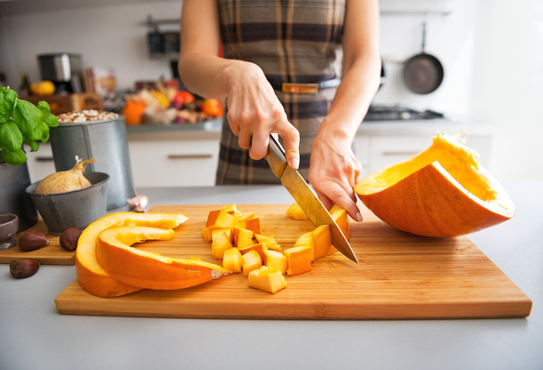 Closeup on young housewife cutting pumpkin - Foto, afbeelding