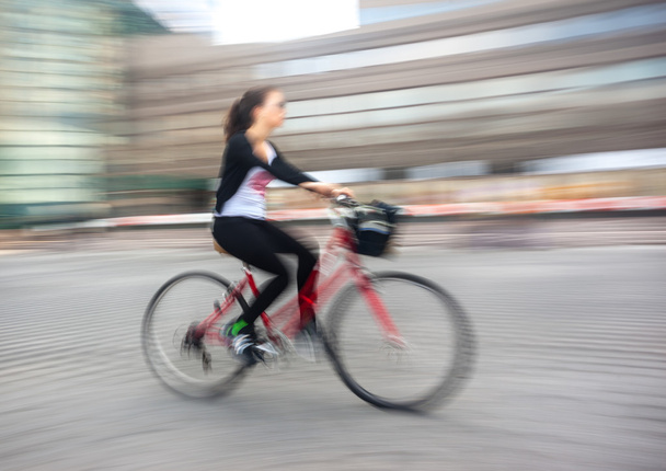 Дівчина-велосипедистка в дорозі по місту
 - Фото, зображення