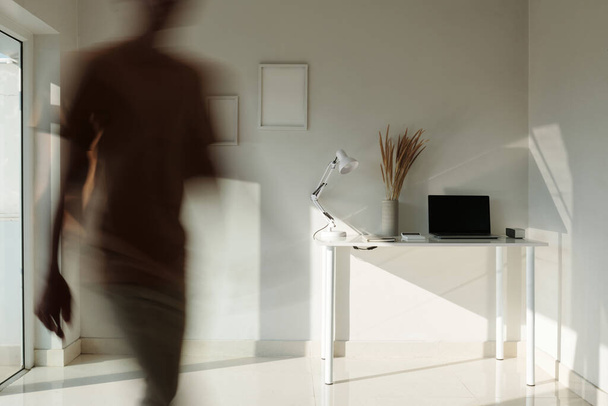 Businessman leaving minimalistic style office, blurred motion - Photo, Image