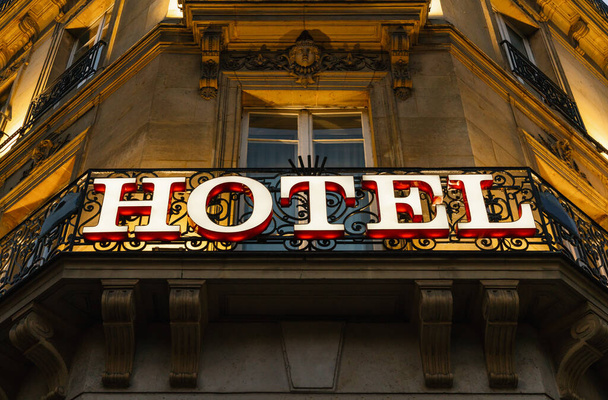 Иллюминированный знак отеля, снятый ночью
 - Фото, изображение