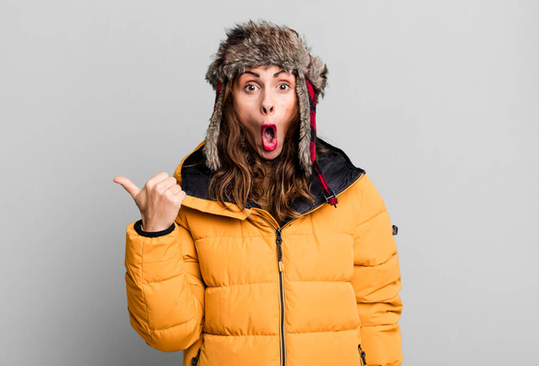 mujer bonita hispana mirando asombrada en incredulidad. usando un anorak. concepto frío e invierno - Foto, Imagen