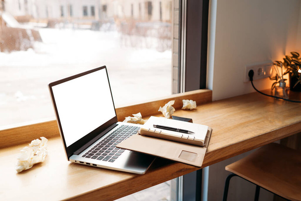 Ordenador portátil con pantalla blanca en blanco juntando con portátil y en la moderna mesa de madera con ventanas en la cafetería como fondo - Foto, imagen