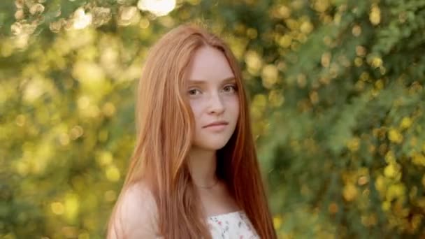 A beautiful young woman opens her eyes, looking at the camera, smiling, having long beautiful red hair.  Attractive girl with beautiful freckles on her face. - Footage, Video