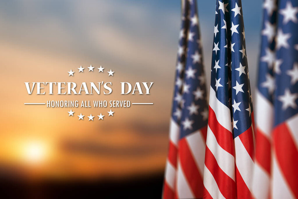 American flags with Text Veterans Day Honoring All Who Served on sunset background. American holiday banner. - Foto, Imagem