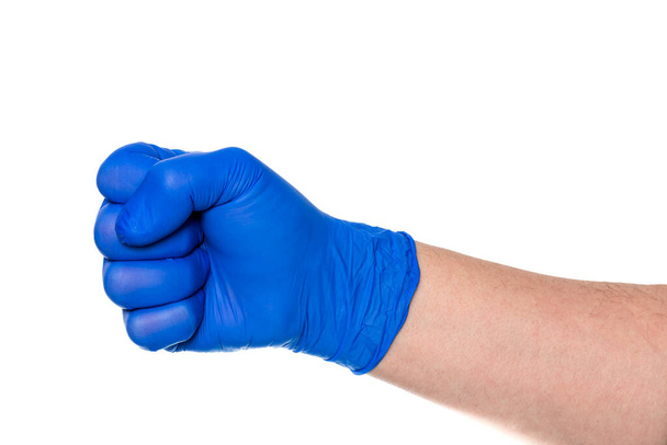 Cortar mano anónima de persona en guante azul látex con puño cerrado contra fondo blanco - Foto, Imagen