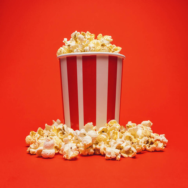 Popcorn dans une boîte autour sur un fond rouge vif - Photo, image