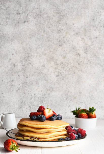 Homemade pancakes with strawberries and blueberries for breakfast. American dessert - Φωτογραφία, εικόνα