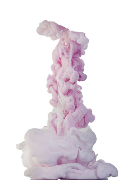 Tinte fiel ins Wasser und wurde in Bewegung fotografiert. Farbe, die im Wasser wirbelt. Rosa und weiße Wolke und Farbrauch im Wasser isoliert auf weißem Hintergrund. - Foto, Bild