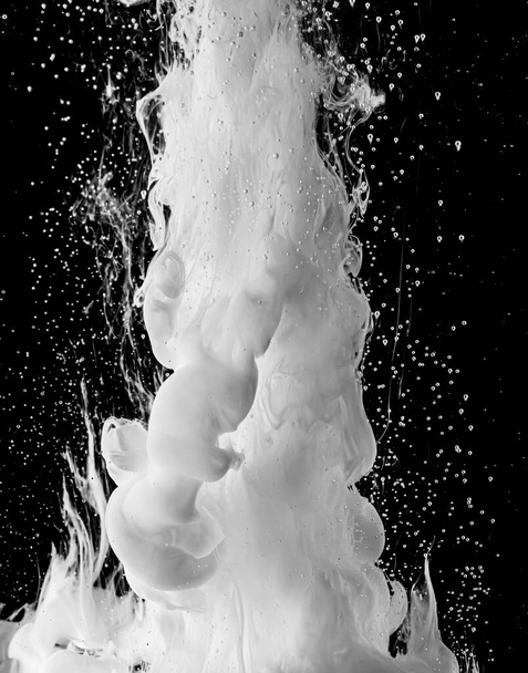 Ink dropped into the water and photographed while in motion. Paint swirling in water. Grey  and white cloud and smoke of paint in water isolated on black background. - Fotografie, Obrázek