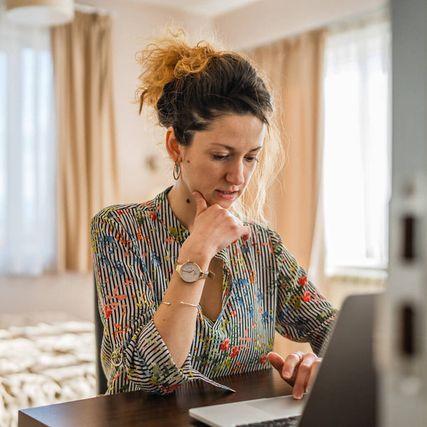 Een vrouw volwassen blanke vrouw werk op laptop computer in de slaapkamer of hotelkamer - Foto, afbeelding