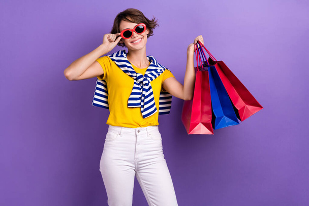 Photo of positive lovely lady wear yellow trendy summer clothes hold packs nice shopping isolated on purple color background. - Φωτογραφία, εικόνα