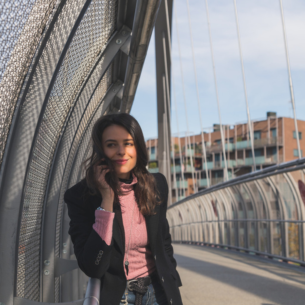 Beautiful young brunette posing on a bridge - Foto, Imagen