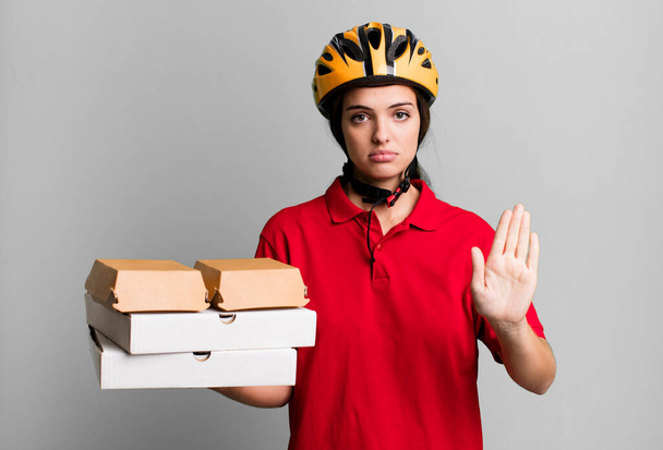 young pretty woman looking serious showing open palm making stop gesture. pizza delivery concept - Foto, Imagem