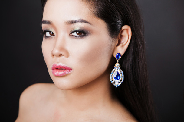 close up portrait of a beautiful brunette asian model with luxury accessories. - Фото, изображение