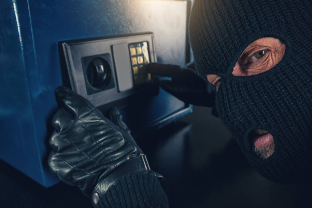 Burglar tries to find the combination code of a safe  - Photo, Image