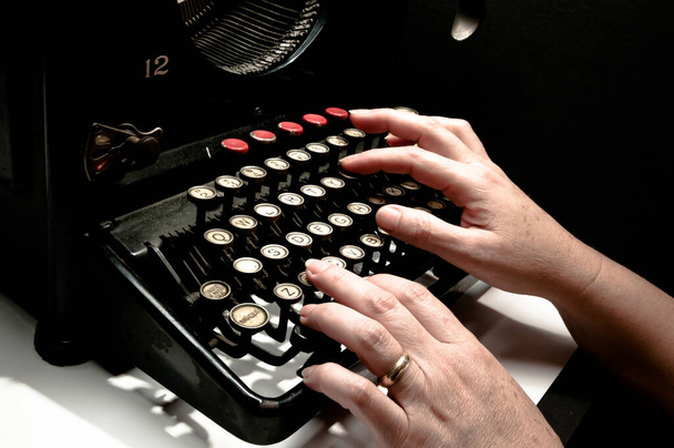 Női kezek gépelés egy antik írógépen, érdekes darab, keveréke művészet, kultúra és a történelmi mérnöki. - Fotó, kép