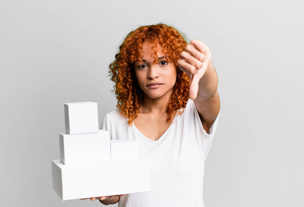 red hair pretty woman feeling cross,showing thumbs down. blank packages boxes concept - Фото, зображення