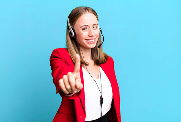 smiling proudly and confidently making number one. telemarketer concept - Фото, зображення