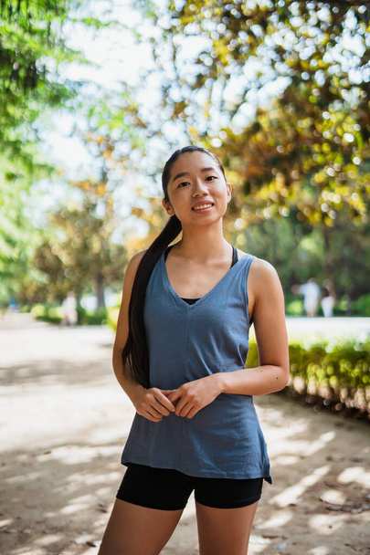 Portrait of asian fitness young woman looking at camera while she is in the park - Foto, imagen