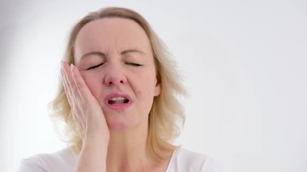 ανυπόφορος πονόδοντο γυναίκα έκλεισε τα μάτια της βάλει το χέρι στο αριστερό μάγουλο θέση της για κείμενο πηγαίνει στο γιατρό δεν καθυστερούν την οδοντιατρική θεραπεία σωστή διατροφή που χρειάζεστε για την προστασία των δοντιών σας - Πλάνα, βίντεο