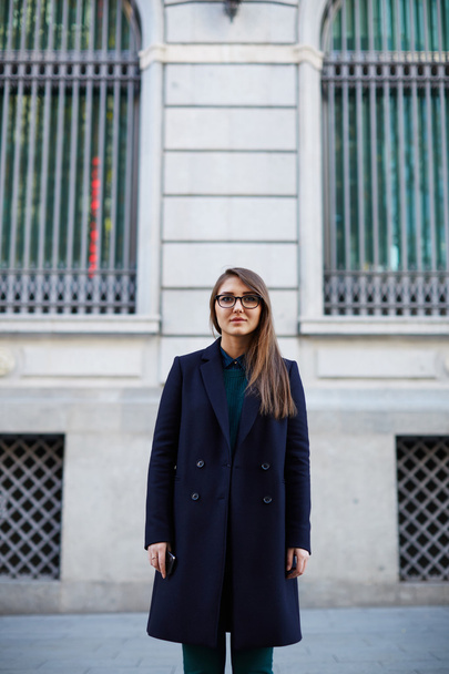 Gorgeous female in stylish coat standing in the city - 写真・画像