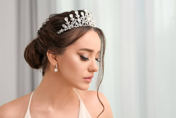 Beautiful young woman wearing luxurious tiara indoors, space for text - Zdjęcie, obraz