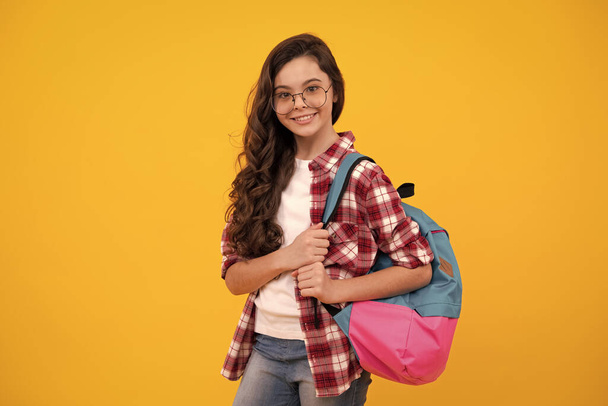 Back to school. Teenage school girl ready to learn. School children on yellow isolated background. Happy teenager, positive and smiling emotions of teen girl - Φωτογραφία, εικόνα