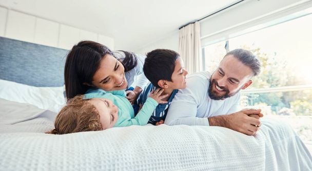 Щаслива, любов і сім'я граються на ліжку разом у спальні свого сучасного будинку. Щастя, захоплення та розваги дітей, ігри та спілкування з батьками в кімнаті вдома
 - Фото, зображення