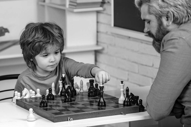 Father teaching son. Teacher and child. Parenthood. Back to school and Education concept. Boy think or plan about chess game - style for education concept - Zdjęcie, obraz