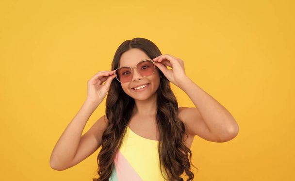 express positive emotions. childhood happiness. summer party look. happy funny kid in eyeglasses. cool teen girl having fun in glasses. cheerful child with long curly hair. fashion accessory. - Photo, Image