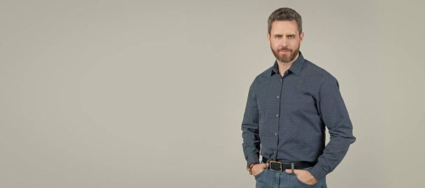 Fashion model wear stylish shirt with casual jeans posing with arms in pockets, wardrobe, copy space. Man face portrait, banner with copy space - Fotoğraf, Görsel