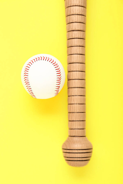 黄色の背景に木製の野球バットとボール、フラットレイアウト。スポーツ用具 - 写真・画像