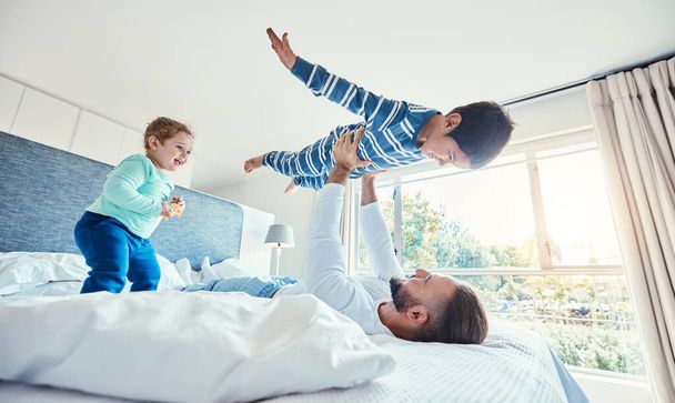 Love, father and boy on bed, airplane and quality time with happiness, break and vacation. Dad, children and kids in bedroom, son in air and smile for playing, games and relax on weekend and bonding. - Foto, Imagem