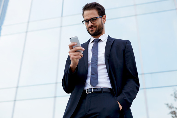 Businessman looking at cell phone - Photo, Image