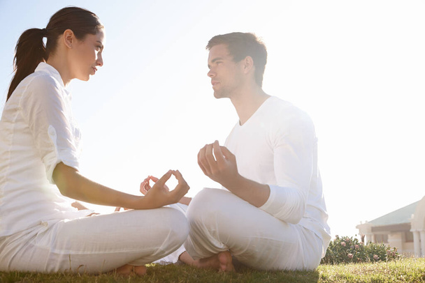 Zeit für einen starren Wettbewerb. Aufnahme eines jungen Paares beim Yoga im Freien in voller Länge - Foto, Bild