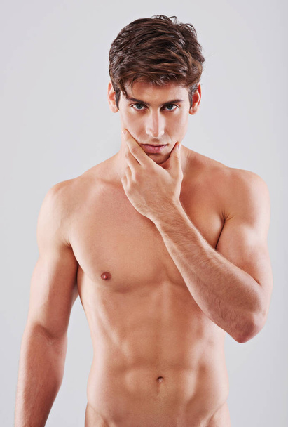 Smoldering manliness. A handsome young shirtless man posing in studio - Foto, Imagen