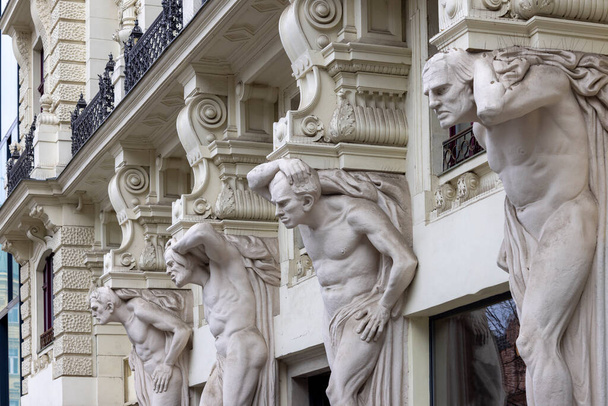 Brno, República Checa - 5 de marzo de 2023: Edificio notable Casa de los Cuatro Gigantes con figuras de cuatro hombres. Fue construido en 1902 en Freedom Square - Foto, Imagen